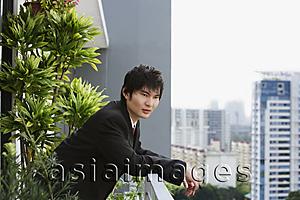 Asia Images Group - young man in suit at balcony