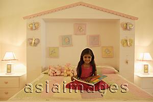 Asia Images Group - little girl reading book on bed