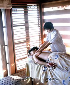 Asia Images Group - Man on table getting a massage from woman
