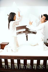 Asia Images Group - Couple holding pillows, fighting