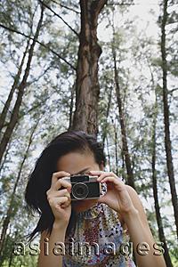 Asia Images Group - Young woman with camera, taking a picture
