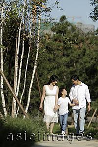 Asia Images Group - Young family holding hands walking down path