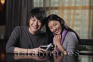 Asia Images Group - Young couple holding a present and smiling