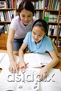 AsiaPix - Girl doing homework, mother standing next to her, pointing at book