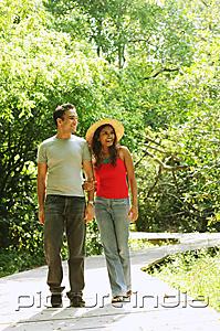 PictureIndia - Man and woman walking side by side in park