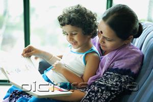 PictureIndia - Daughter sitting on mothers lap, reading a book
