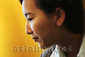Asia Images Group - Female executive, profile, yellow background
