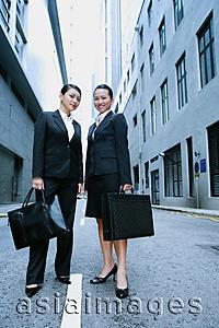 Asia Images Group - Business women standing side by side looking at camera