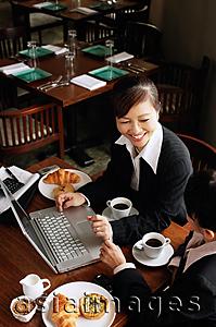 Asia Images Group - Two businesswomen at cafe with laptop