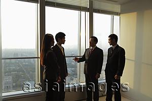 Asia Images Group - Businesspeople talking in front of a window in an office