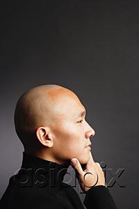 AsiaPix - Man with shaved head, hand on chin, looking away