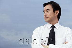 AsiaPix - Businessman with arms crossed, looking to the side
