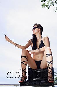AsiaPix - Woman in bikini and high heels, sitting in chair, holding mobile phone