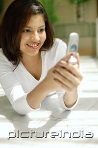 PictureIndia - Woman looking at mobile phone, smiling
